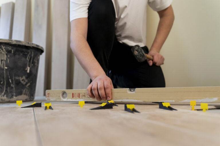 low angle man tiling floor